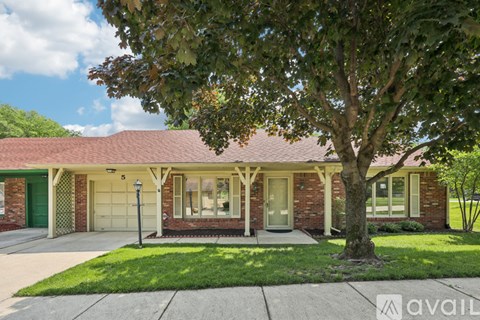 A house with a red roof and a tree in front.