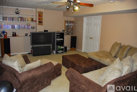 A living room with a brown couch and a television.