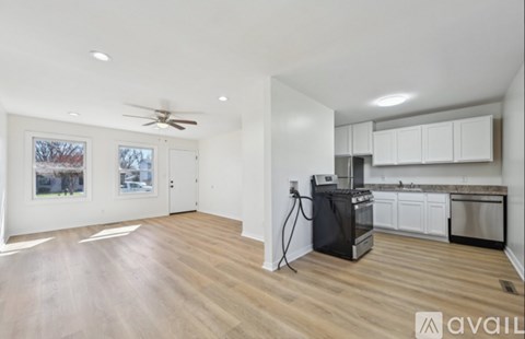A kitchen with white cabinets and a black dishwasher.