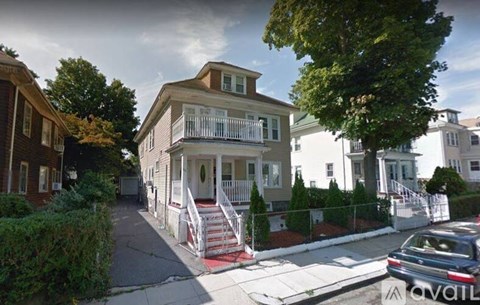 A two-story house with a red staircase leading to the front door.