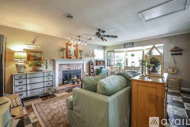A living room with a fireplace, a couch, and a rug.