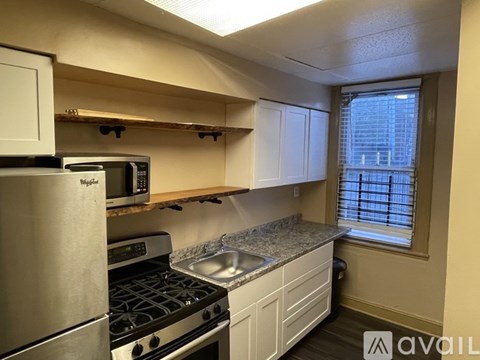 A kitchen with a stove, microwave, and cabinets.