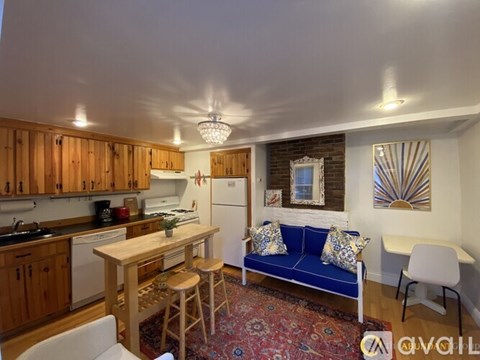 A kitchen with wooden cabinets and a blue couch.