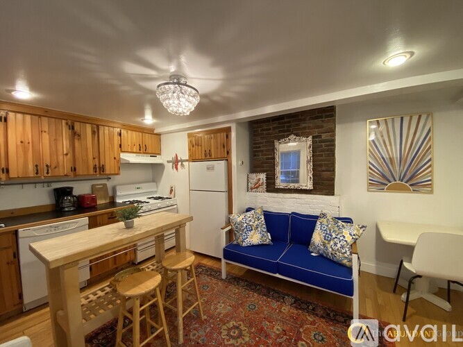 A kitchen with wooden cabinets and a blue couch.