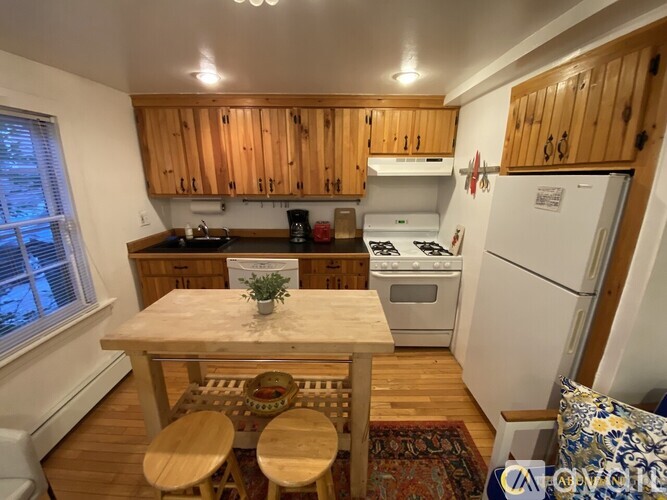 A kitchen with wooden cabinets and a white refrigerator.