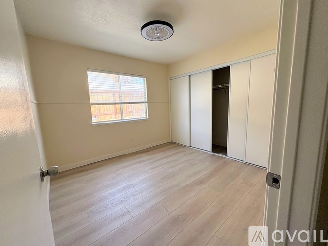 A room with a window and a door is available for rent.