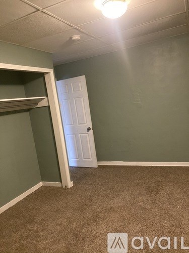 A room with a carpeted floor and a white door.