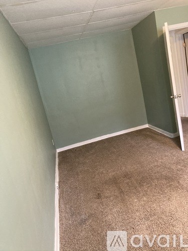 A room with a carpeted floor and a door.