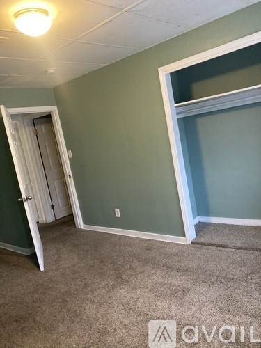 A room with a carpeted floor and a doorway leading to another room.