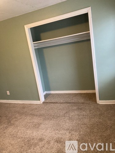 A room with a carpeted floor and a wall with a window.