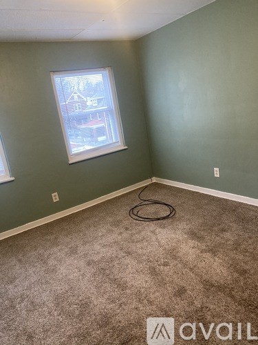 A room with a window and a hose on the floor.