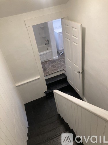 A white door is open to a bathroom.