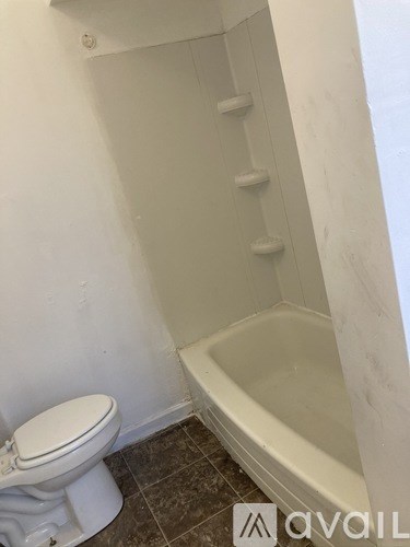 A white toilet sits next to a bathtub in a bathroom.
