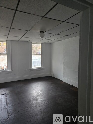 A room with a window and a wooden floor.