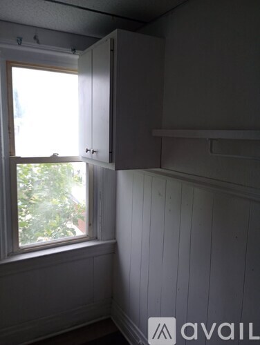 A room with a window and a cabinet.