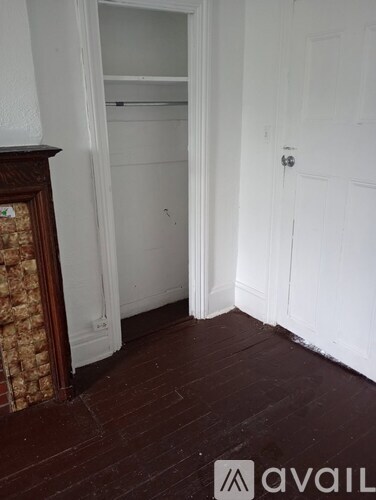 A room with a white door and a wooden floor.
