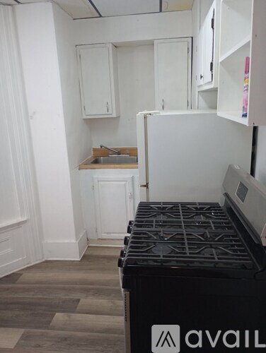 A kitchen with a black stove top oven and white cabinets.