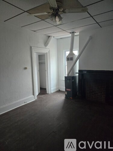 A room with a ceiling fan and a doorway leading to another room.