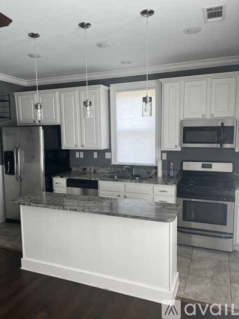 A kitchen with a granite countertop and stainless steel appliances.
