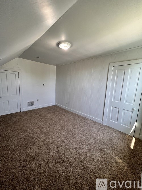 A room with carpeted floor and white walls.
