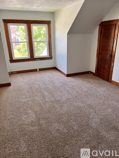 A room with a carpeted floor and a window.