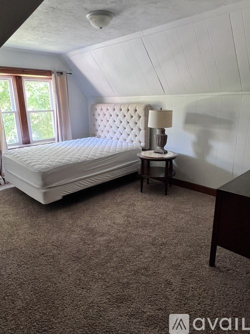 A room with wooden floors and a window with blinds.