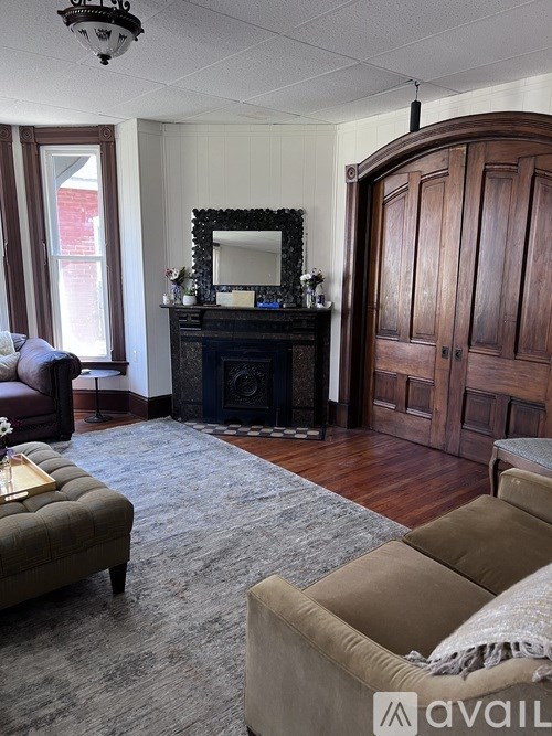 A living room with a fireplace and a mirror above it.