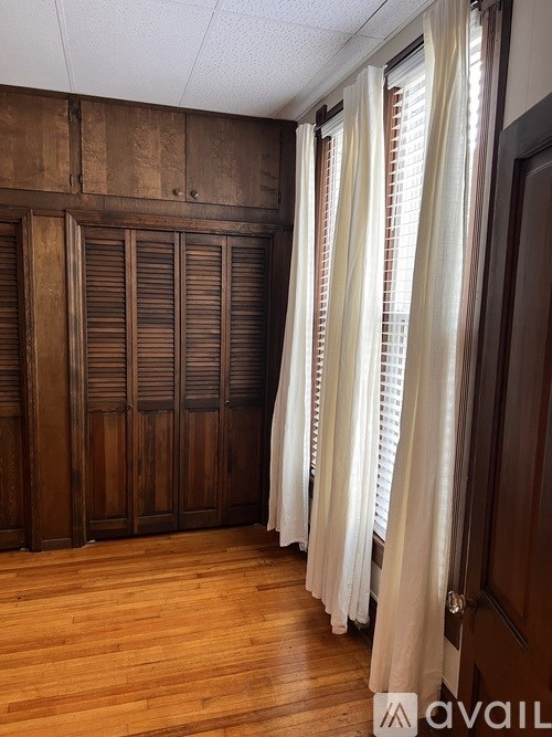 A small white closet with a toilet in the corner.