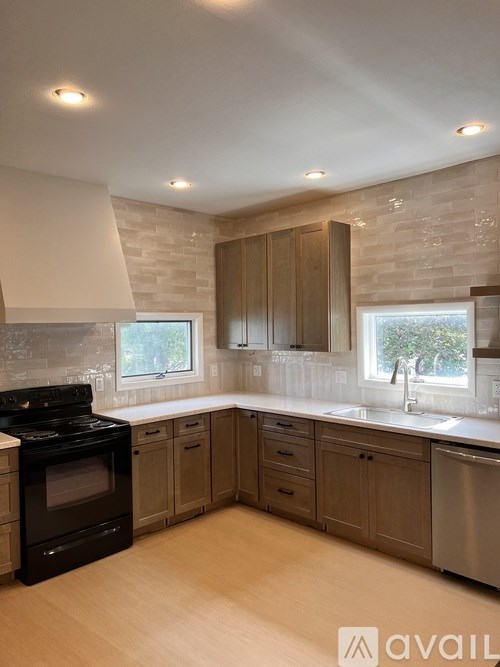 A kitchen with wooden cabinets and a black stove top oven.