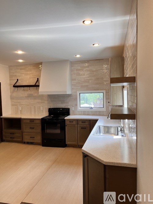 A kitchen with a black oven and wooden cabinets.