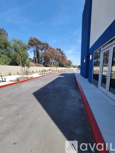 A parking lot with a blue line on the ground and a building on the right side.