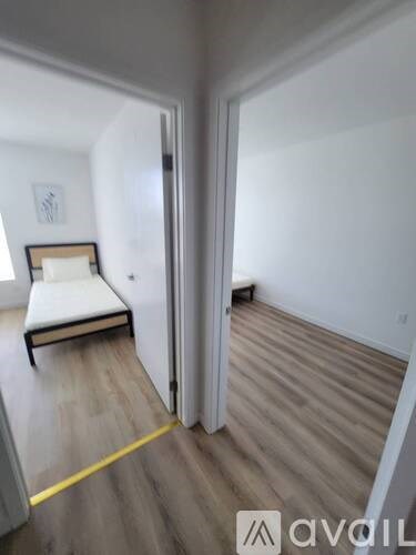 A room with a bed and a yellow line on the floor.