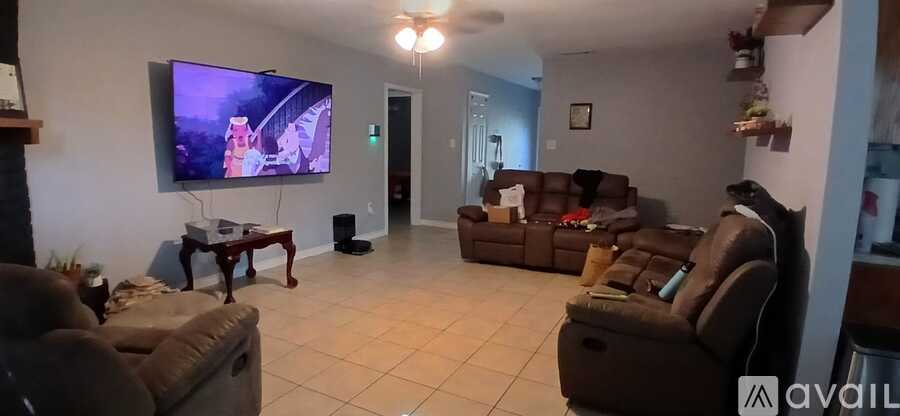 A living room with a large television and comfortable seating.