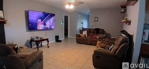 A living room with a large television and comfortable seating.