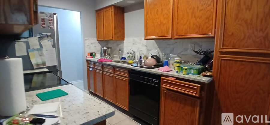A kitchen with wooden cabinets and a marble countertop.