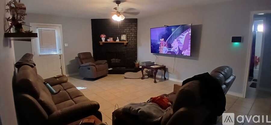 A living room with a flat screen TV mounted on the wall.