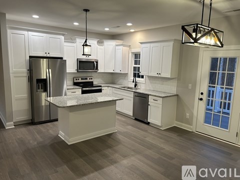 A modern kitchen with a large island and stainless steel appliances.