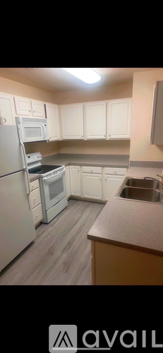 A kitchen with white cabinets and a refrigerator.
