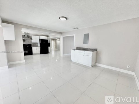 A spacious kitchen with white cabinets and appliances.