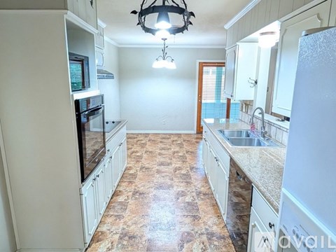 A kitchen with a tile floor and white appliances.