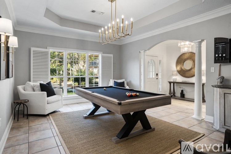 A pool table is in the middle of a room with a couch and a chair.
