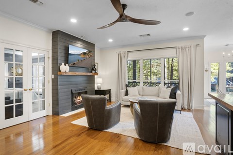 A living room with a fireplace and a painting on the wall.