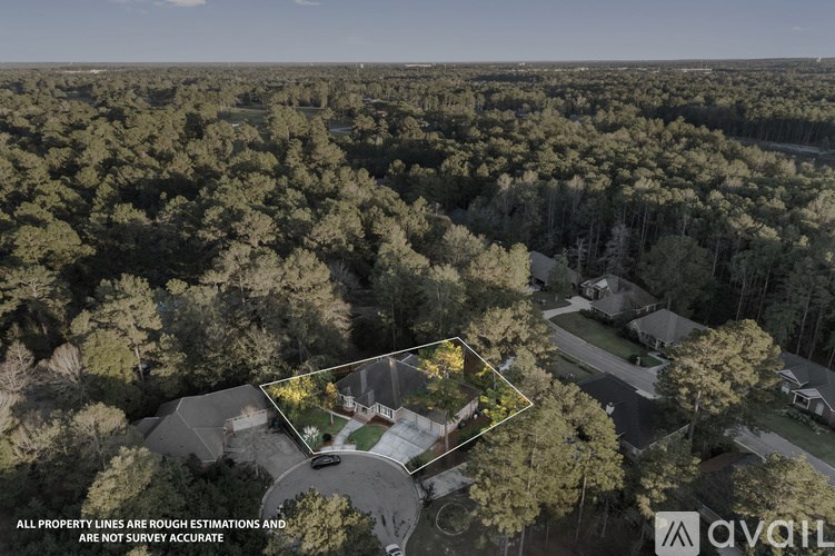 An aerial view of a property surrounded by trees with a disclaimer about the property lines.