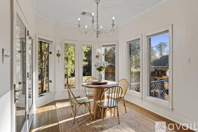 A dining room with a round table and chairs.