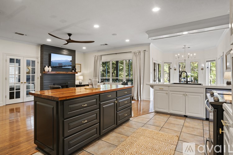 A modern kitchen with dark wood cabinets and a wooden island.