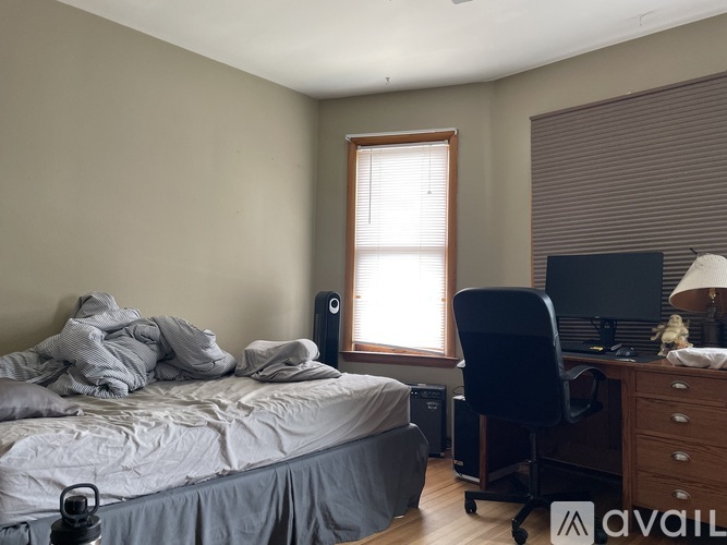 A bedroom with a bed, desk, and chair.