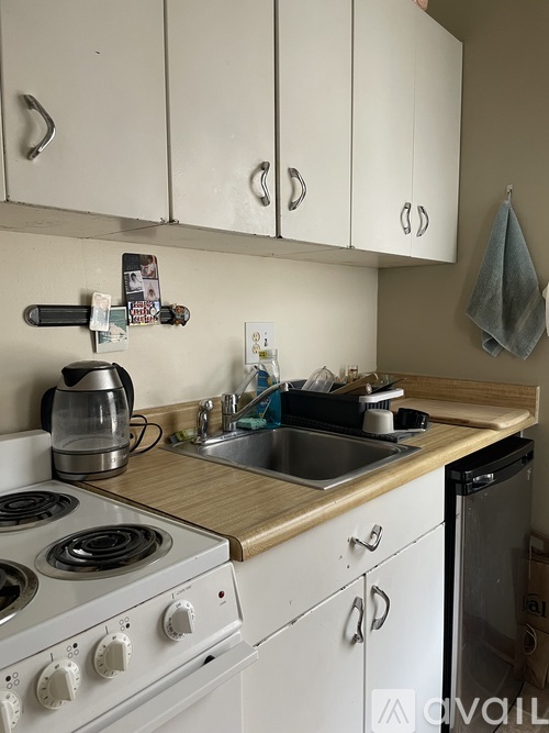 A kitchen with white cabinets and a wooden counter top.