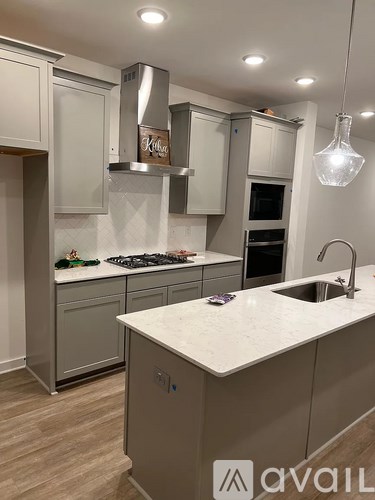 A kitchen with a white countertop and a stainless steel range hood.