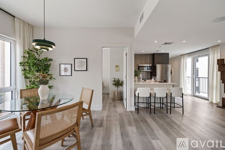 A modern dining room with a glass table and chairs.
