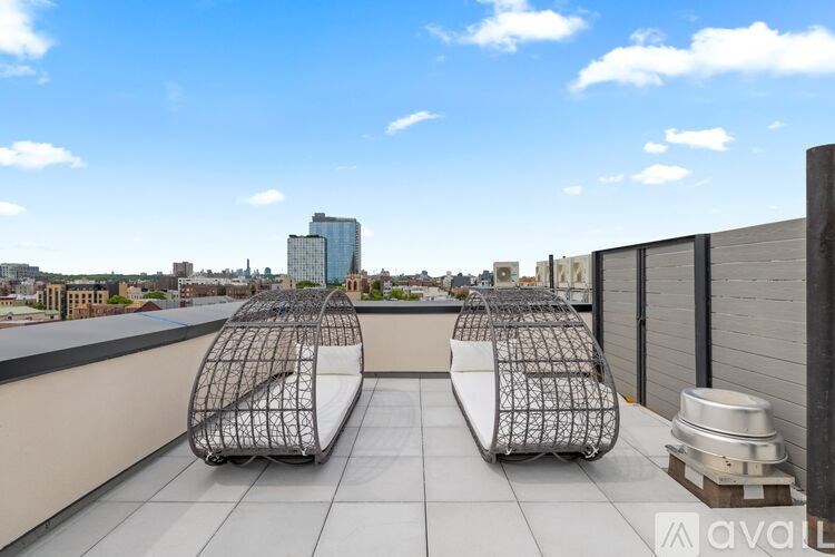 Two metal chairs are placed on a rooftop.